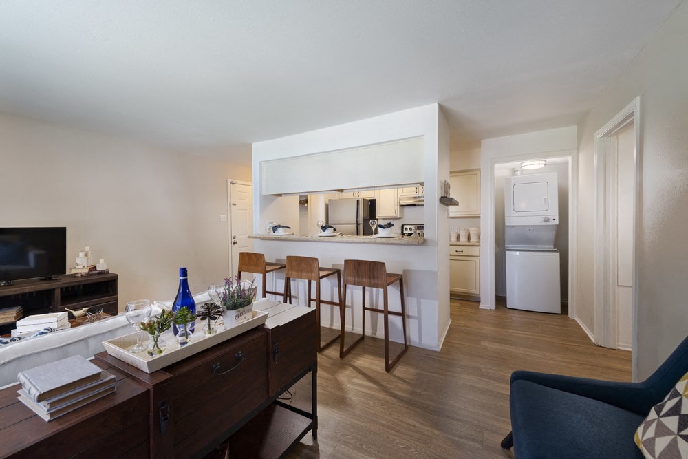a living room and kitchen with a dining room table and chairs