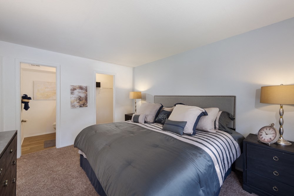 a bedroom with a large bed and a door to a bathroom