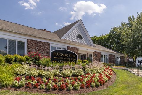 the front of the potomac vista leasing center with flowers and a sign