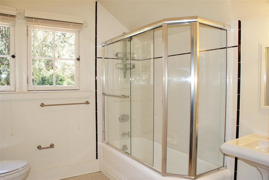 a bathroom with a shower and a sink and a window