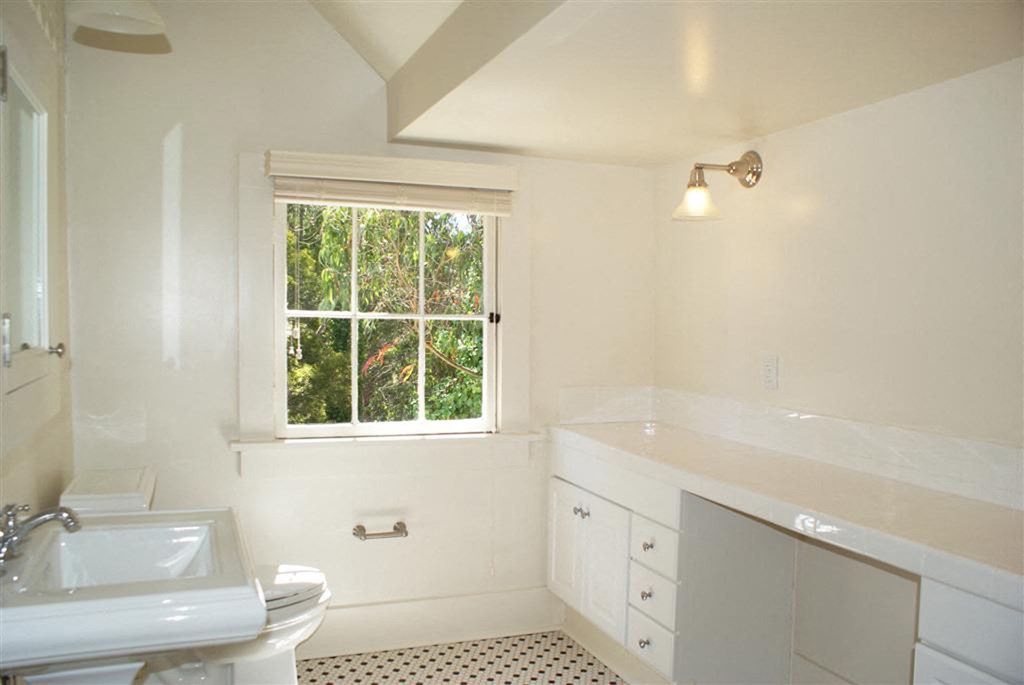 a bathroom with a sink toilet and a window