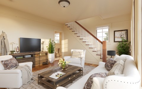 a living room with white furniture and a tv
