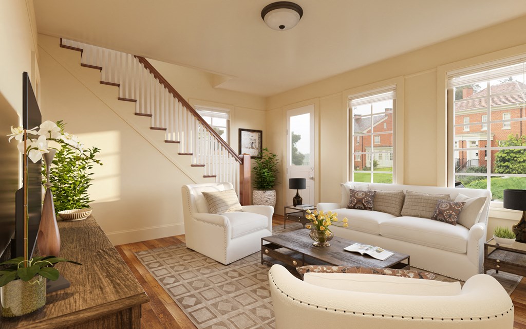 a living room with white couches and chairs and a staircase