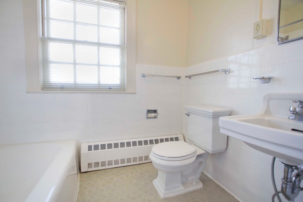 a bathroom with a toilet and a sink and a window