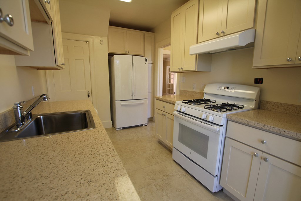 a kitchen with white appliances and white cabinets