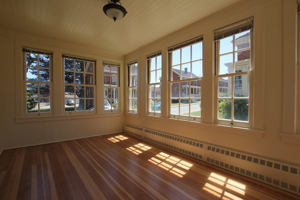 a living room with large windows and a wooden floor