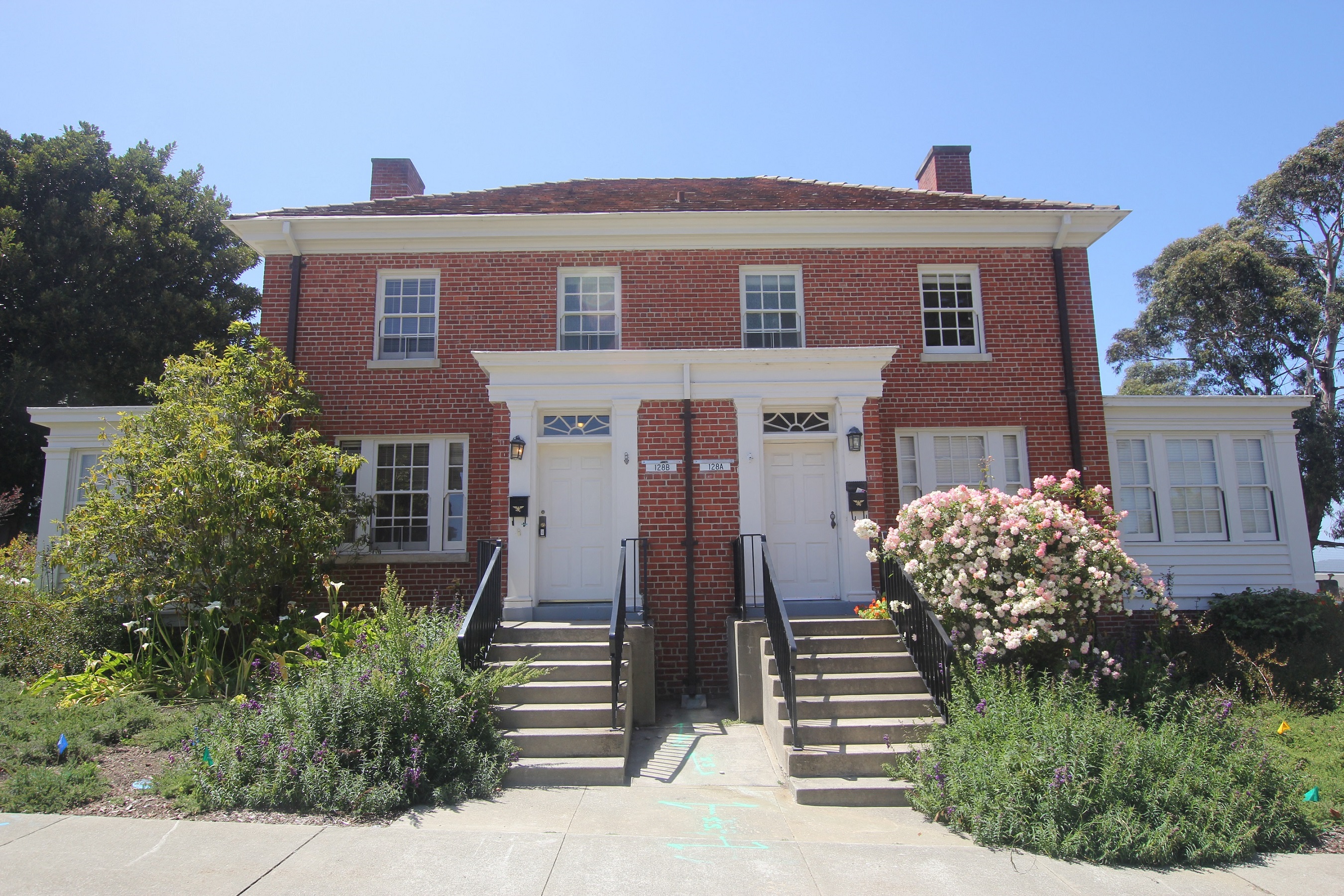 a red brick house with white doors and stairs