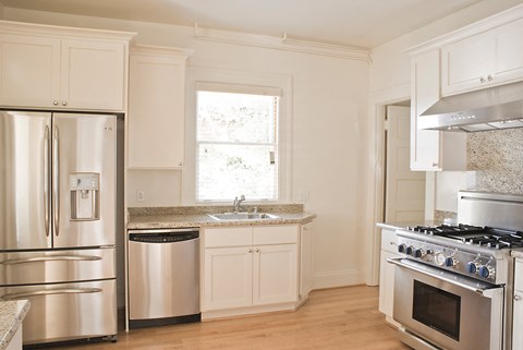 a kitchen with stainless steel appliances and white cabinets