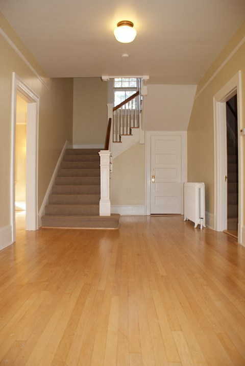 a living room with a hard wood floor and a staircase