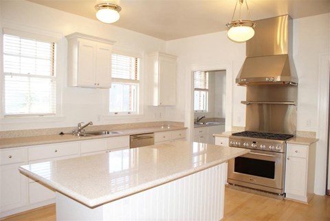 a large white kitchen with a stove and a sink