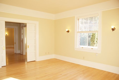 an empty living room with a window and a door