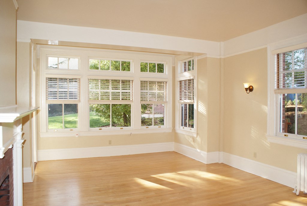 a living room with large windows and a wooden floor