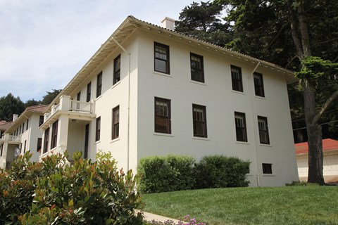 a white building with black windows and a lawn in front of it