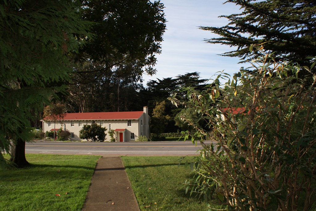 a white building with a red roof next to a street