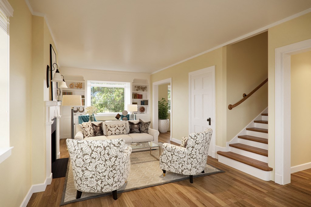 a living room with a couch and chairs and a staircase