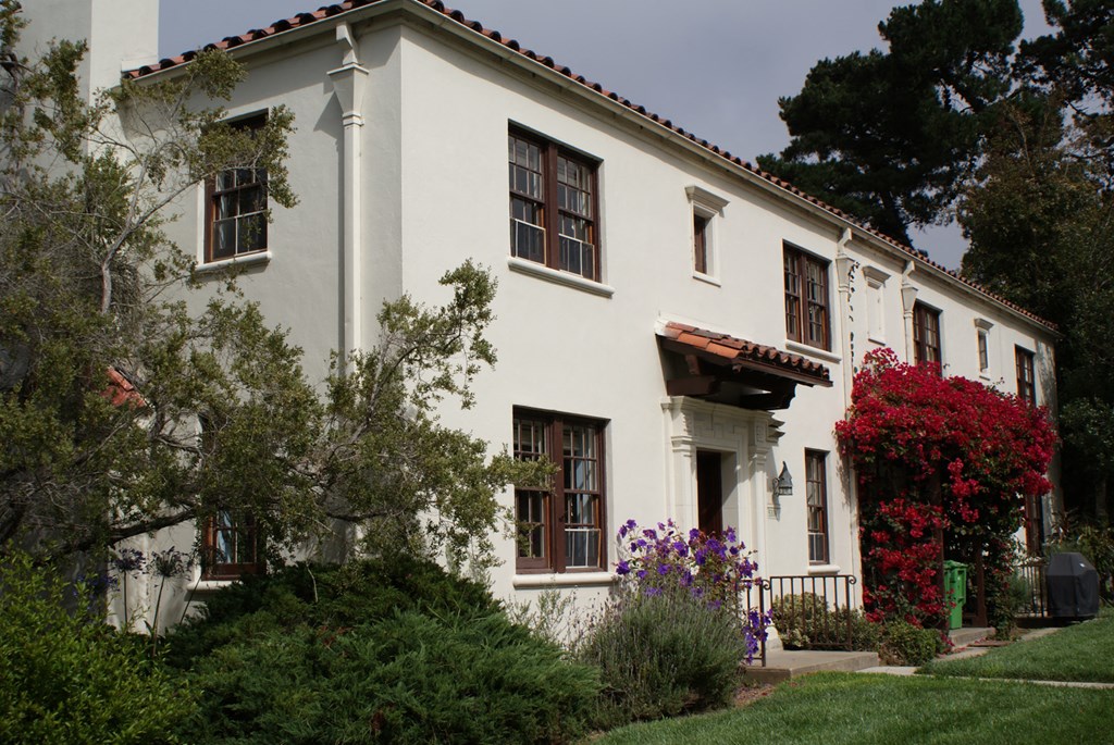 a white house with a garden in front of it