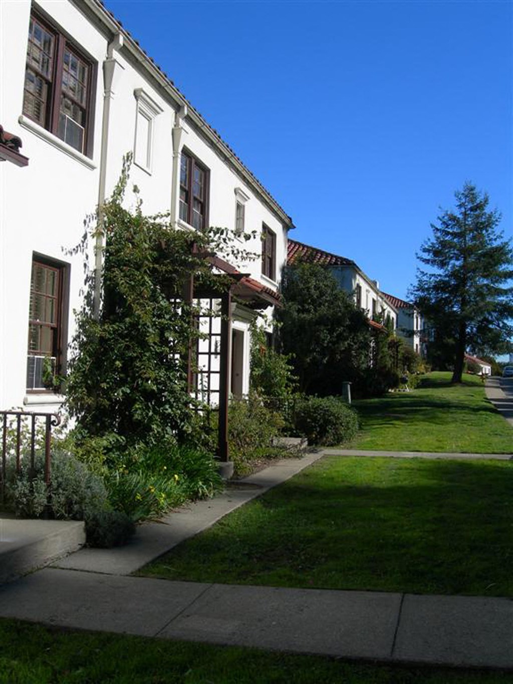 a row of houses on the side of a sidewalk