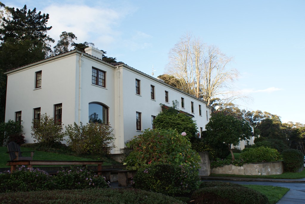 a white house with a garden in front of it