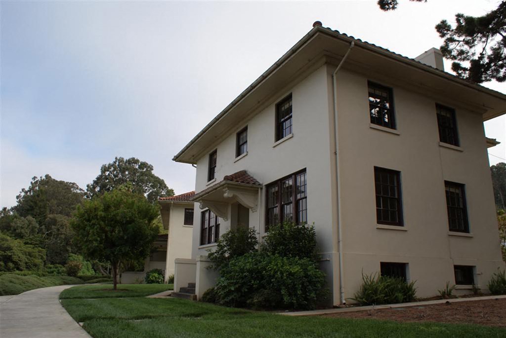 a white house with a sidewalk in front of it
