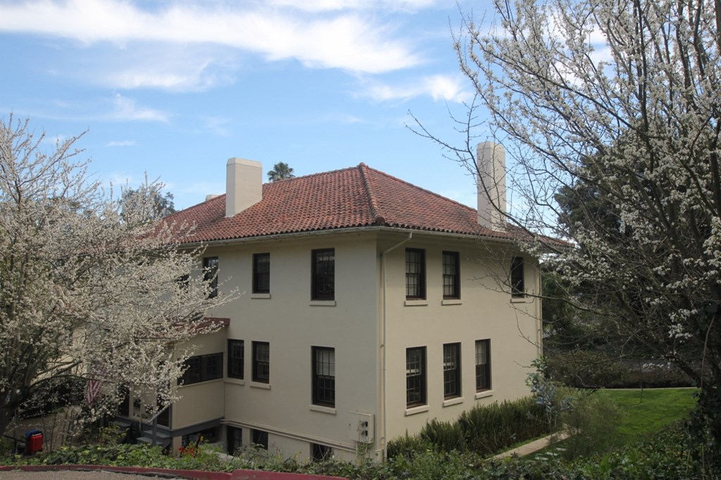 a large white house with a red roof and some trees