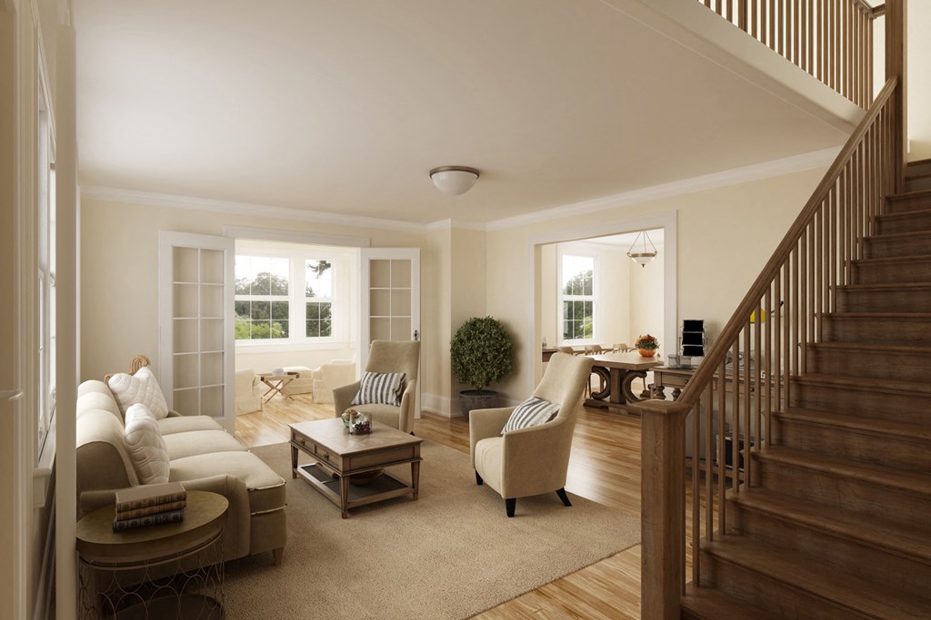 a living room with couches and chairs and a staircase