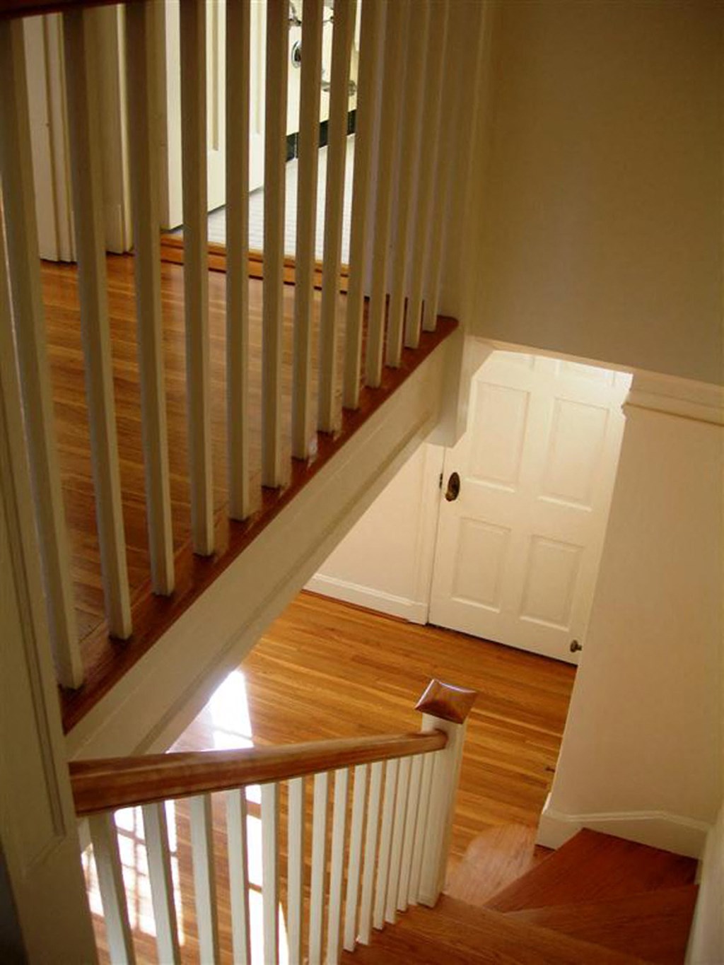 a staircase in a house with wood floors and a door
