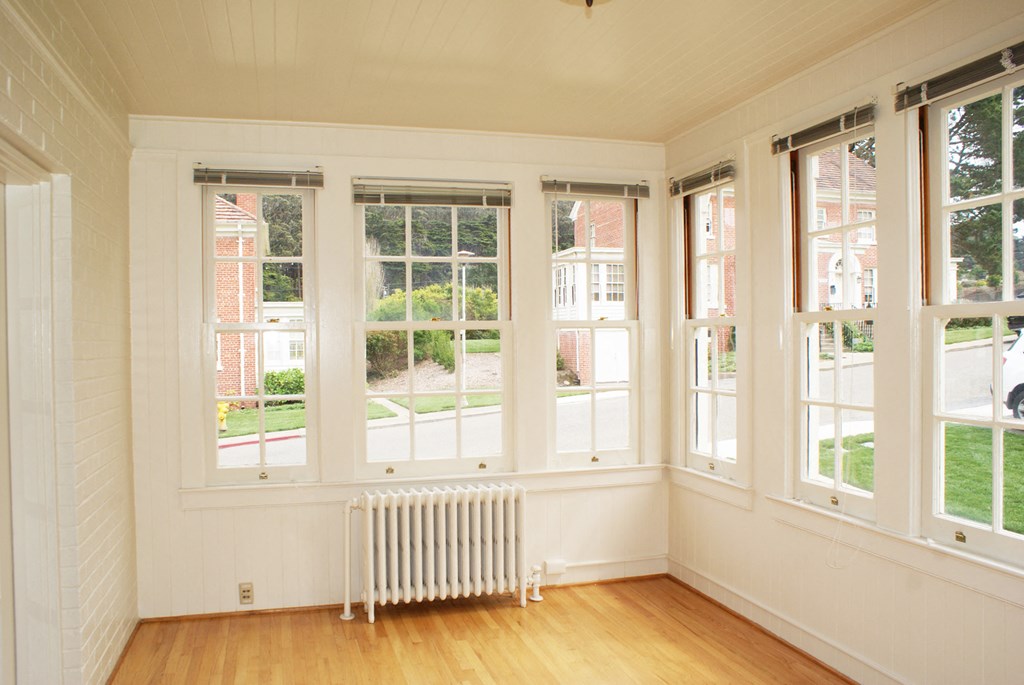 a living room with a radiator and five windows