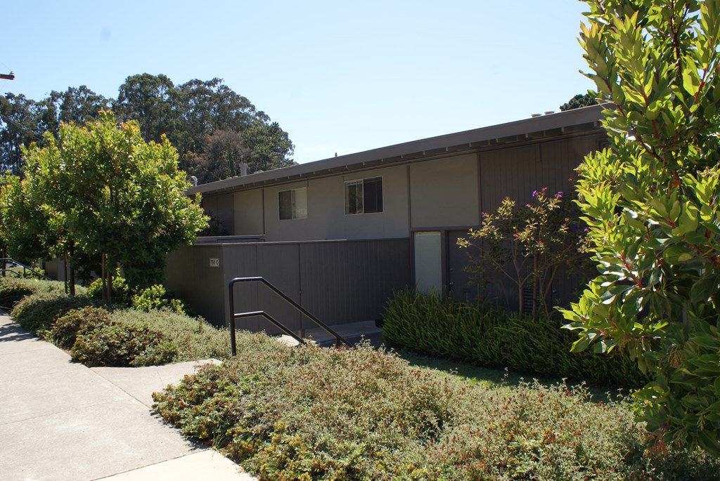 the front of a house with stairs and a sidewalk