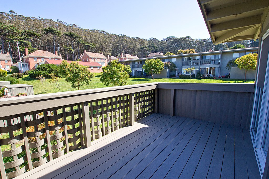 a balcony with a view of a yard and houses