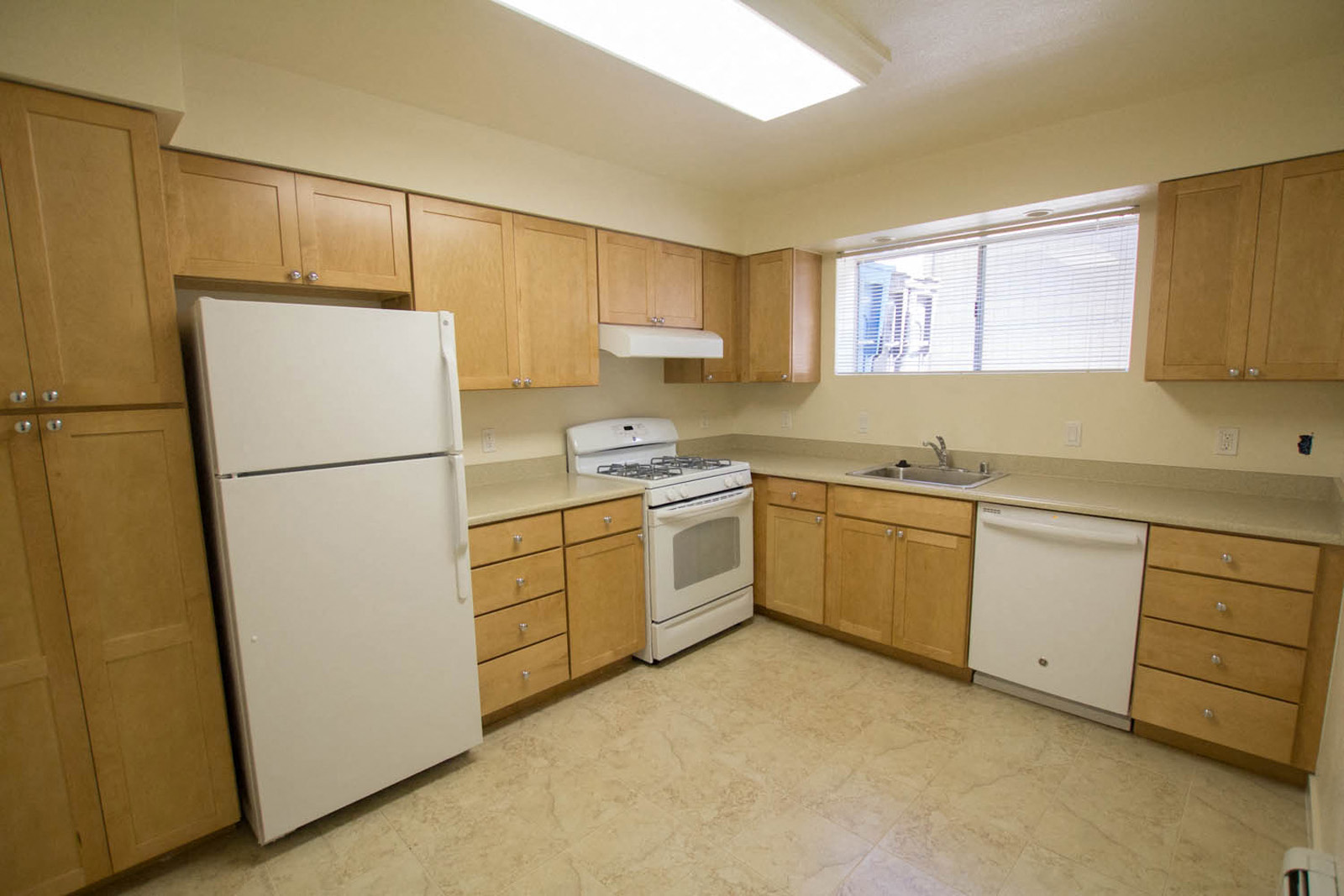 a kitchen with white appliances and wooden cabinets