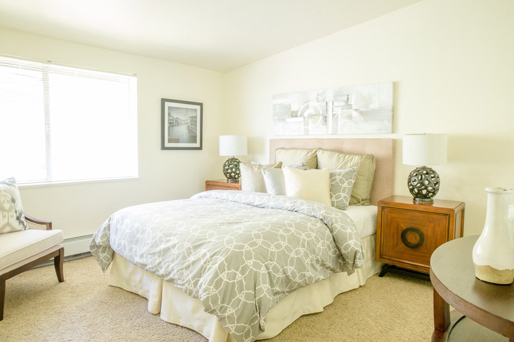 a bedroom with a bed and two night stands and a window