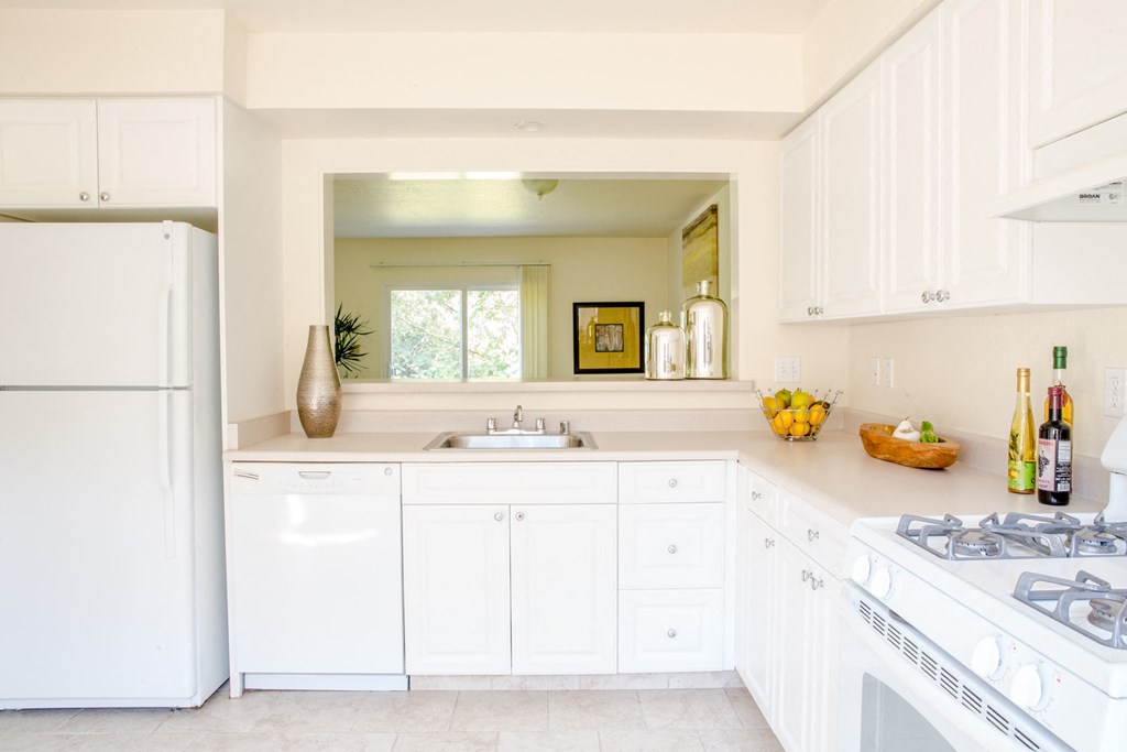 a kitchen with white cabinets and a sink and a refrigerator