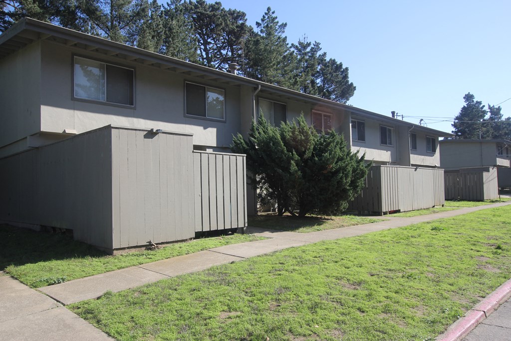 the exterior of an apartment building with a sidewalk in front of it