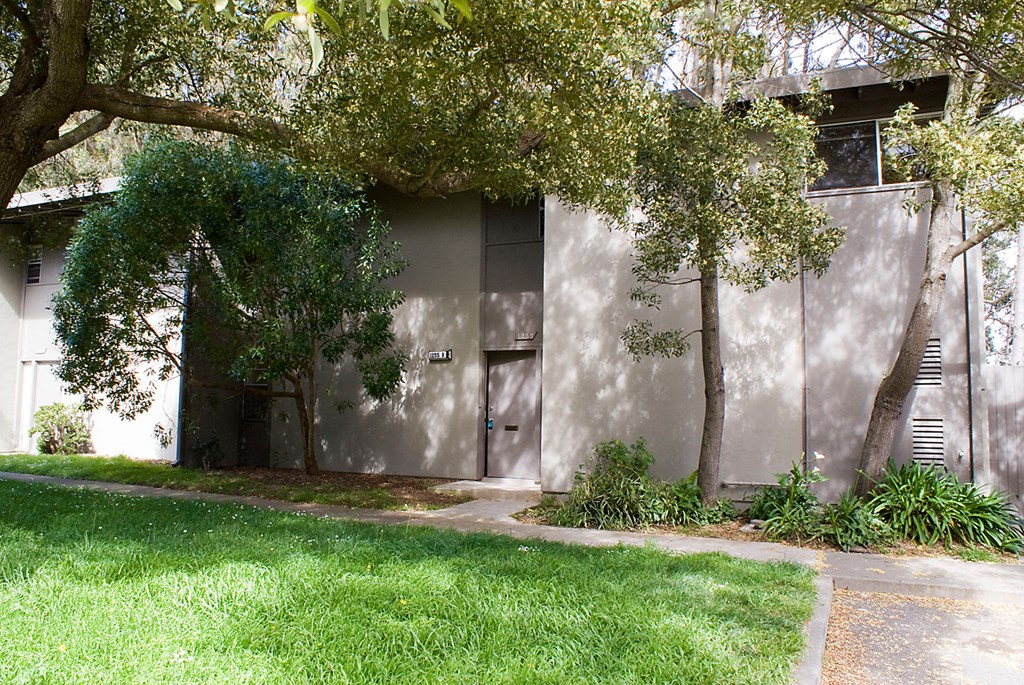 a building with a door and trees in front of it