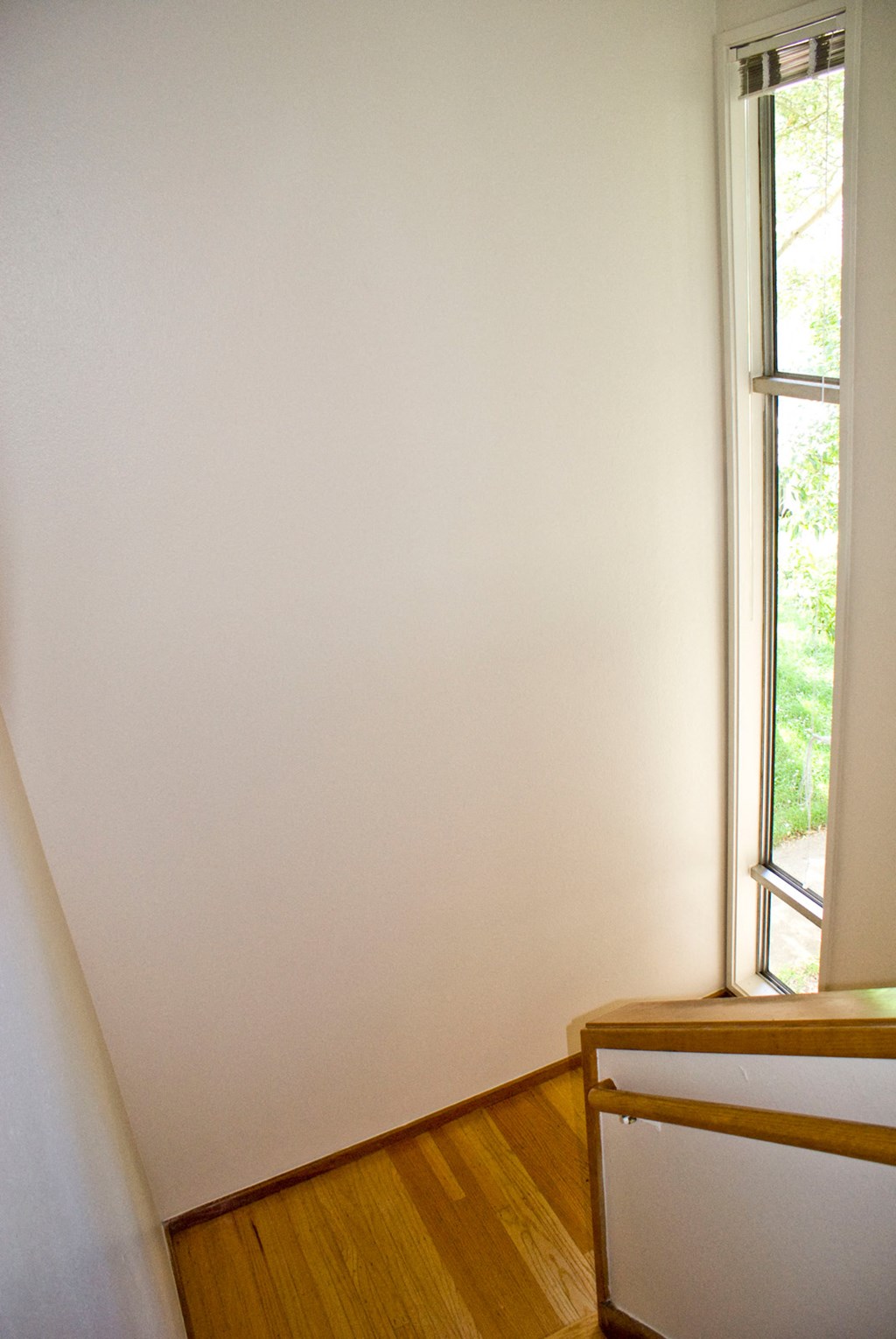 an empty room with two windows and a wooden floor