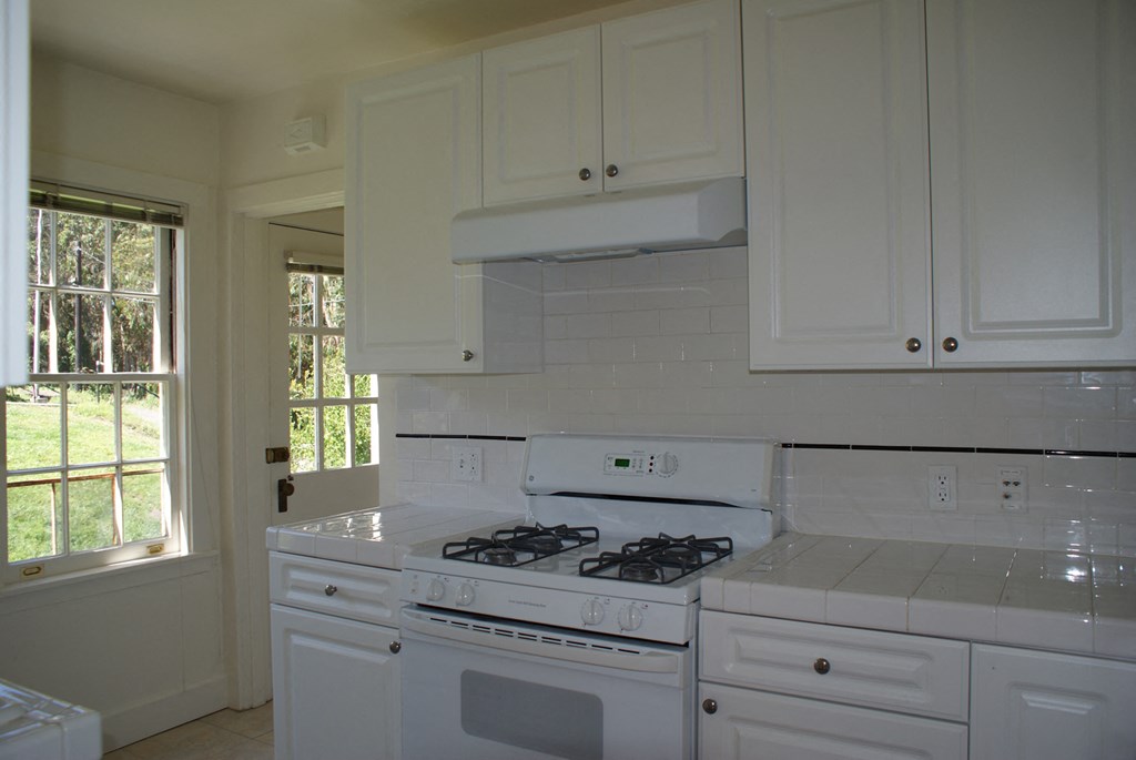 a kitchen with white appliances and white cabinets