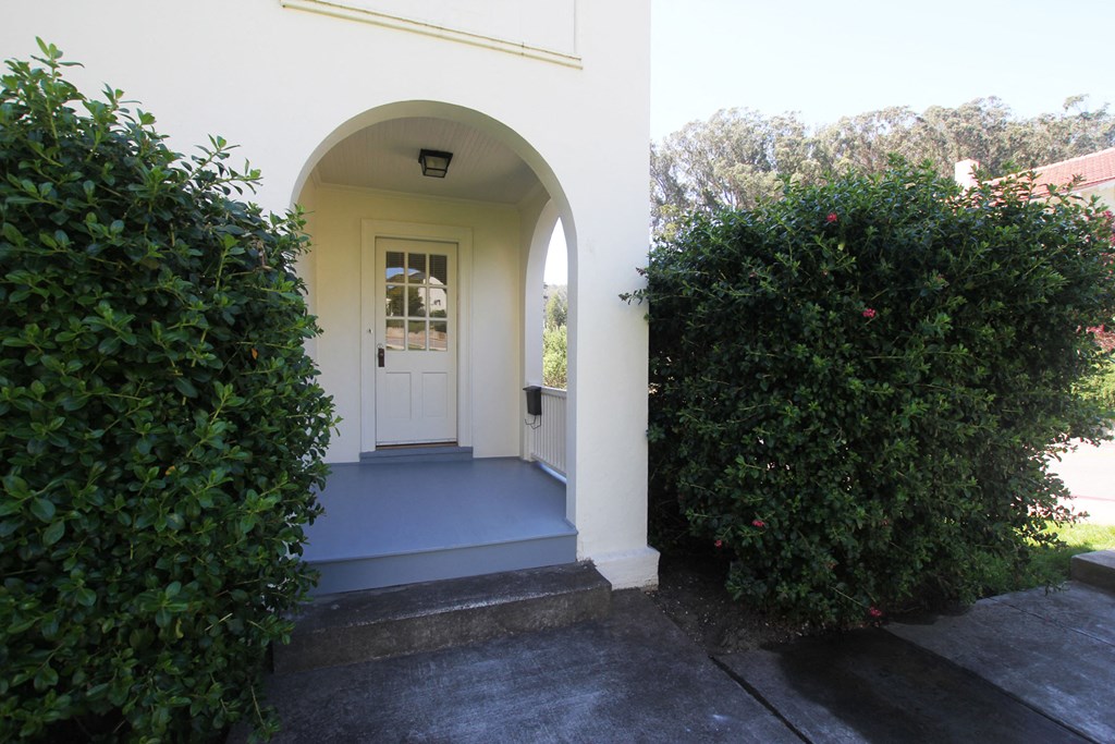 the front door of a house with a blue porch
