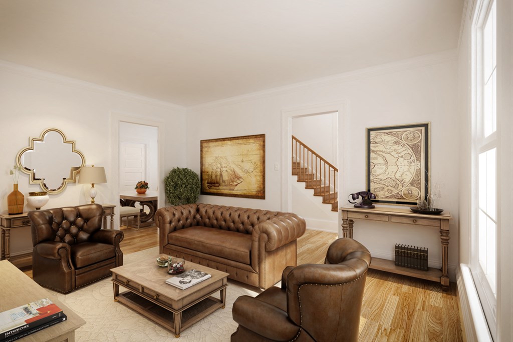 a living room with leather furniture and a staircase