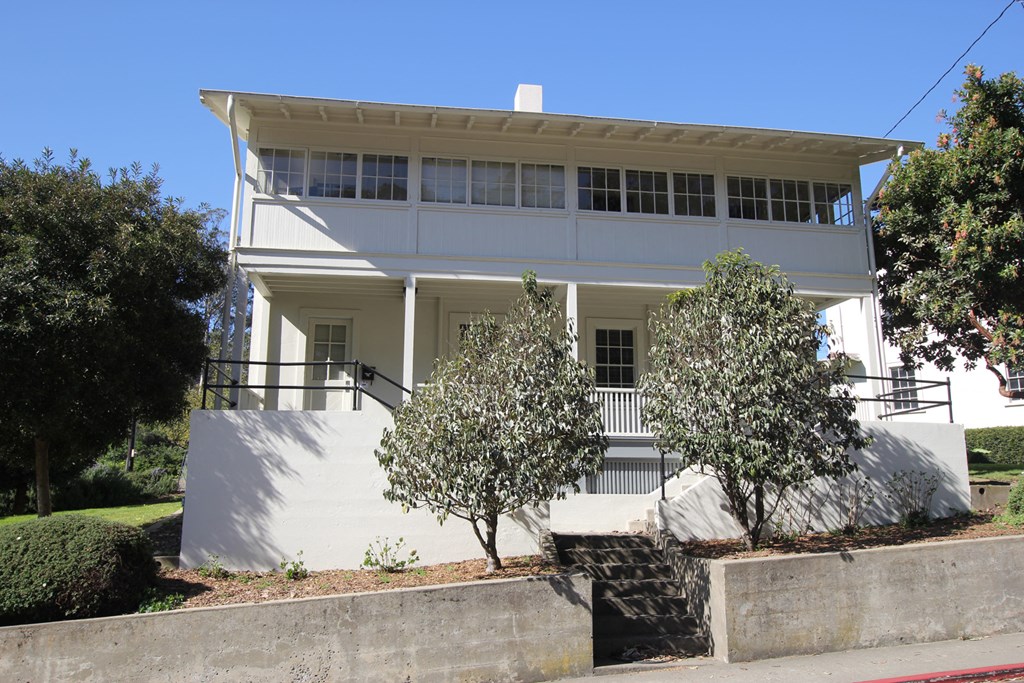 a white house with two trees in front of it