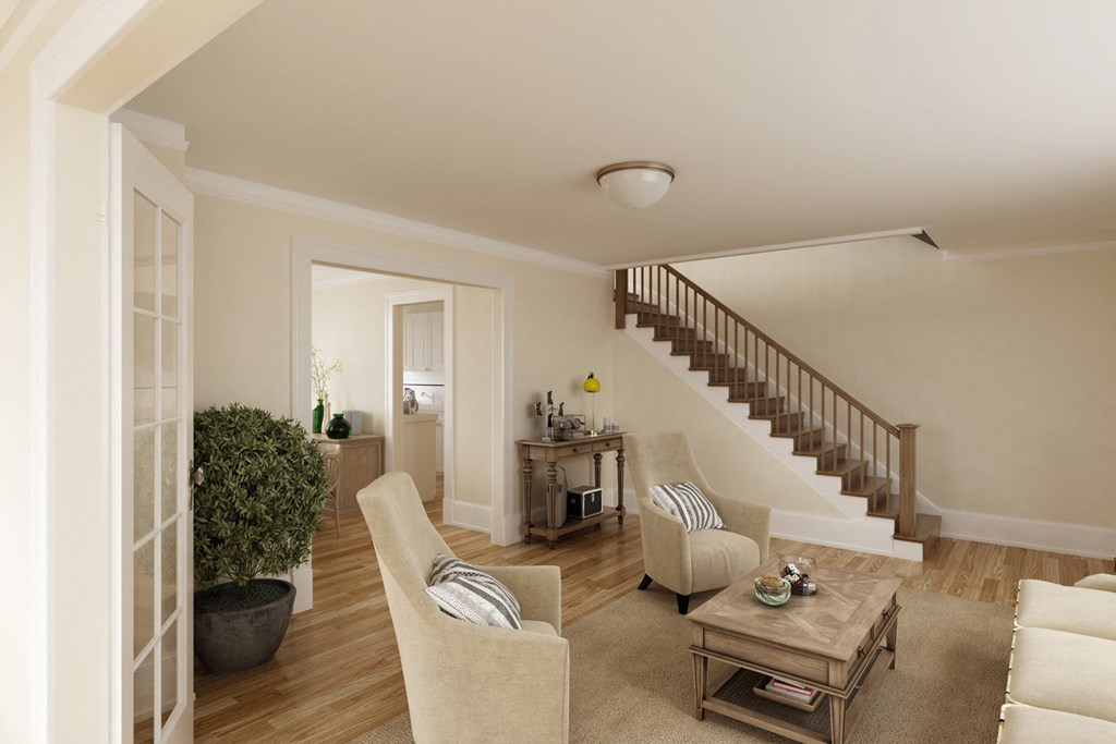 a living room with chairs and a table and a staircase