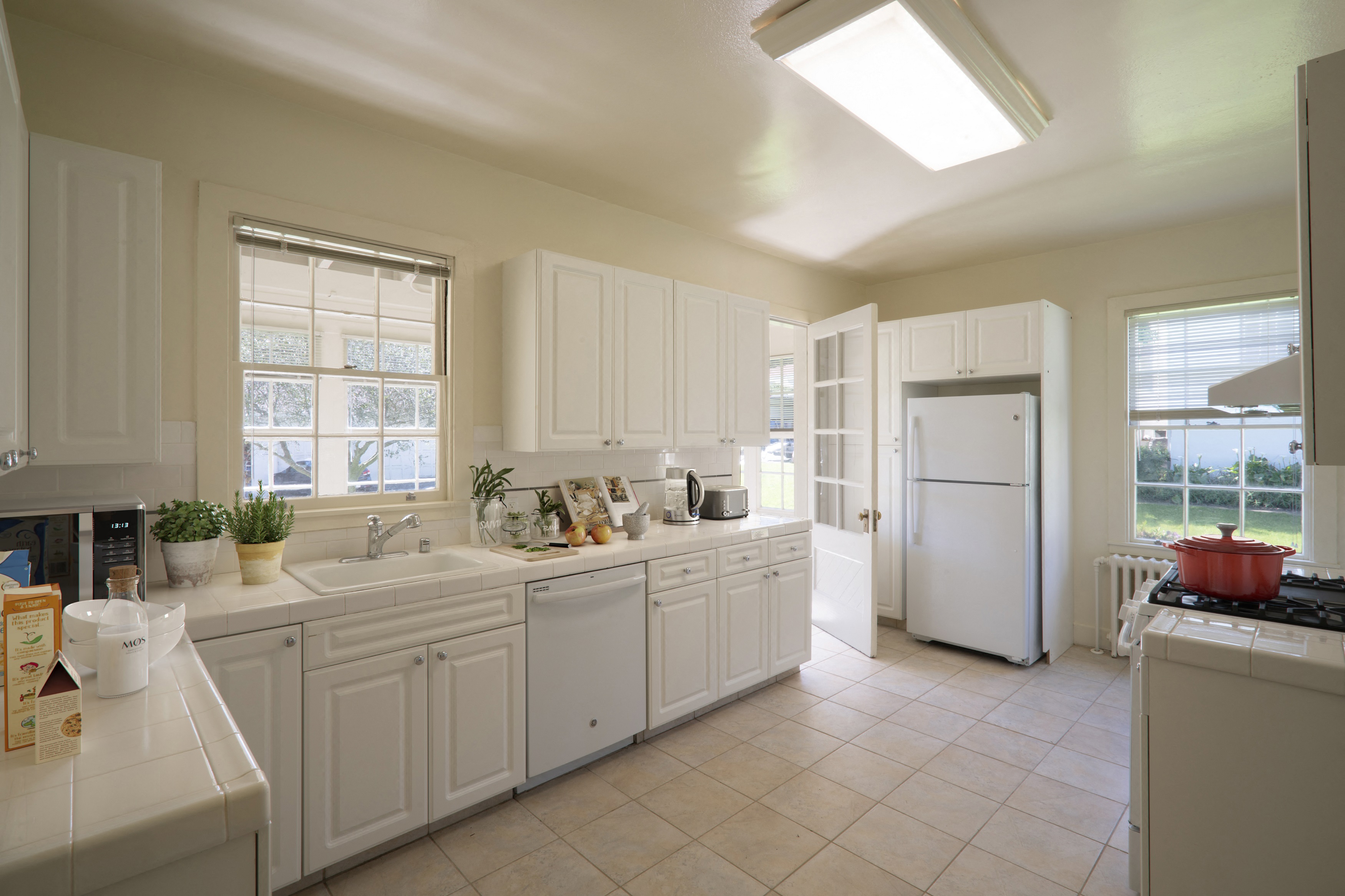 a kitchen with white cabinets and a sink and a refrigerator