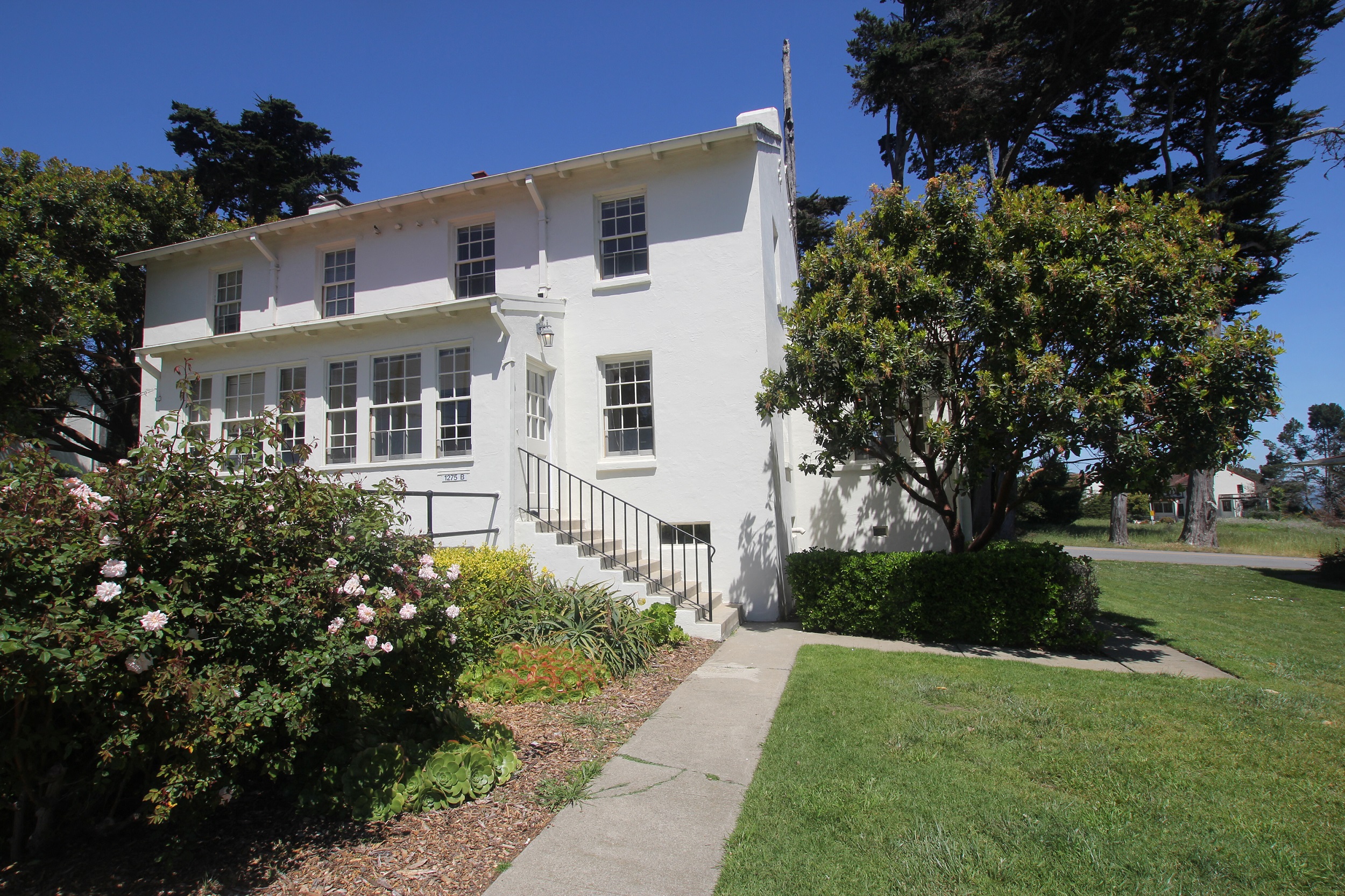 a white house with a sidewalk in front of it