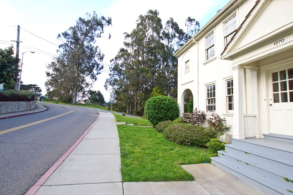 a street in front of a white building