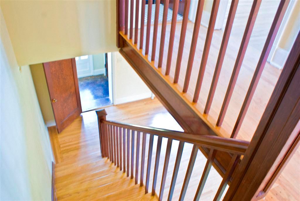a stairwell in a home with wood floors and a door