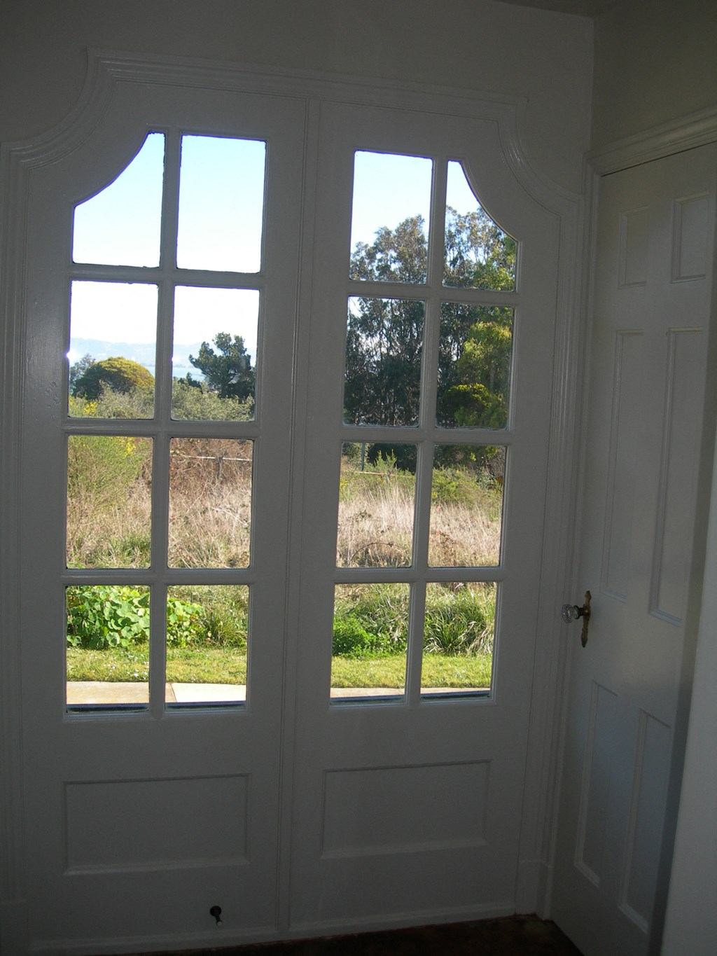 a pair of large glass doors with a view of a field