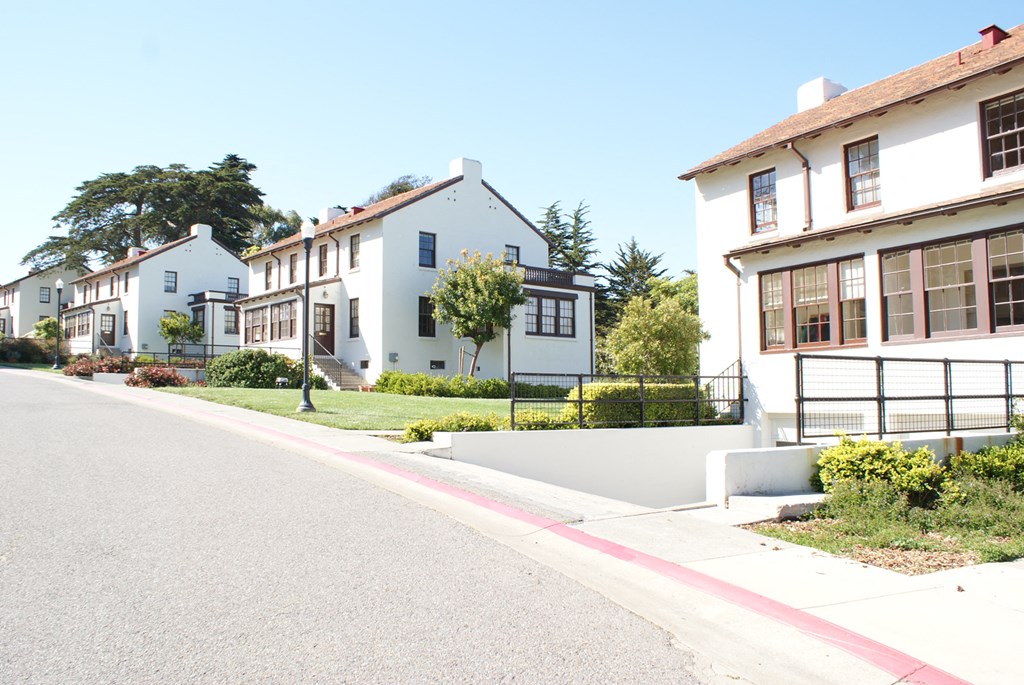 a row of white houses on the side of a street