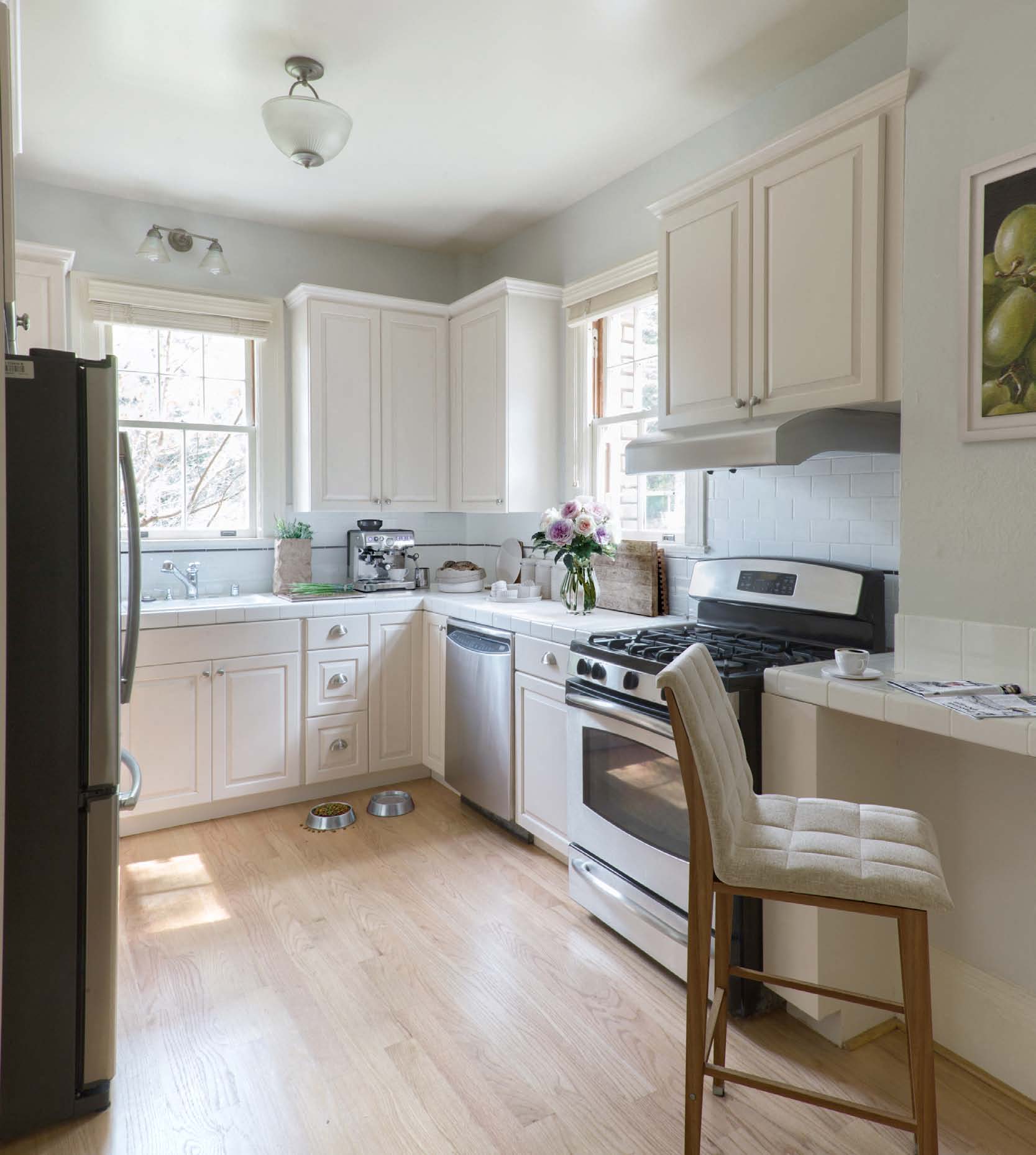 a kitchen with white cabinets and stainless steel appliances