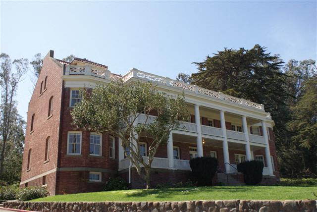 a large brick house with a tree in front of it