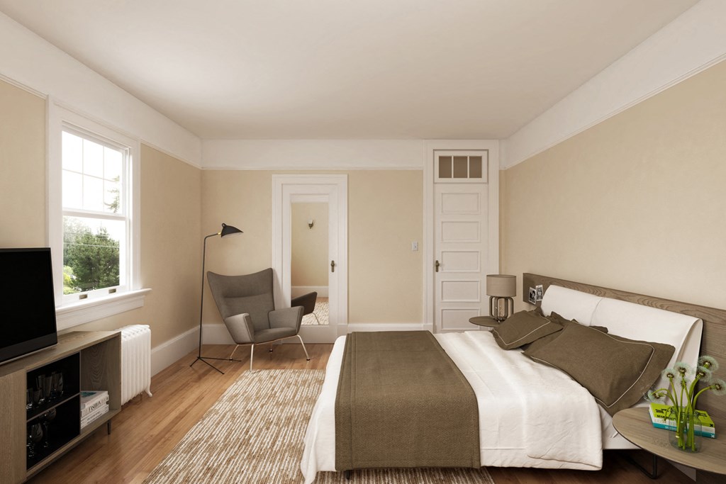 a bedroom with a bed and a chair and a tv