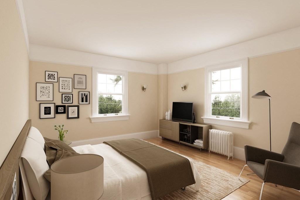 the living room of a bedroom with a bed and a tv